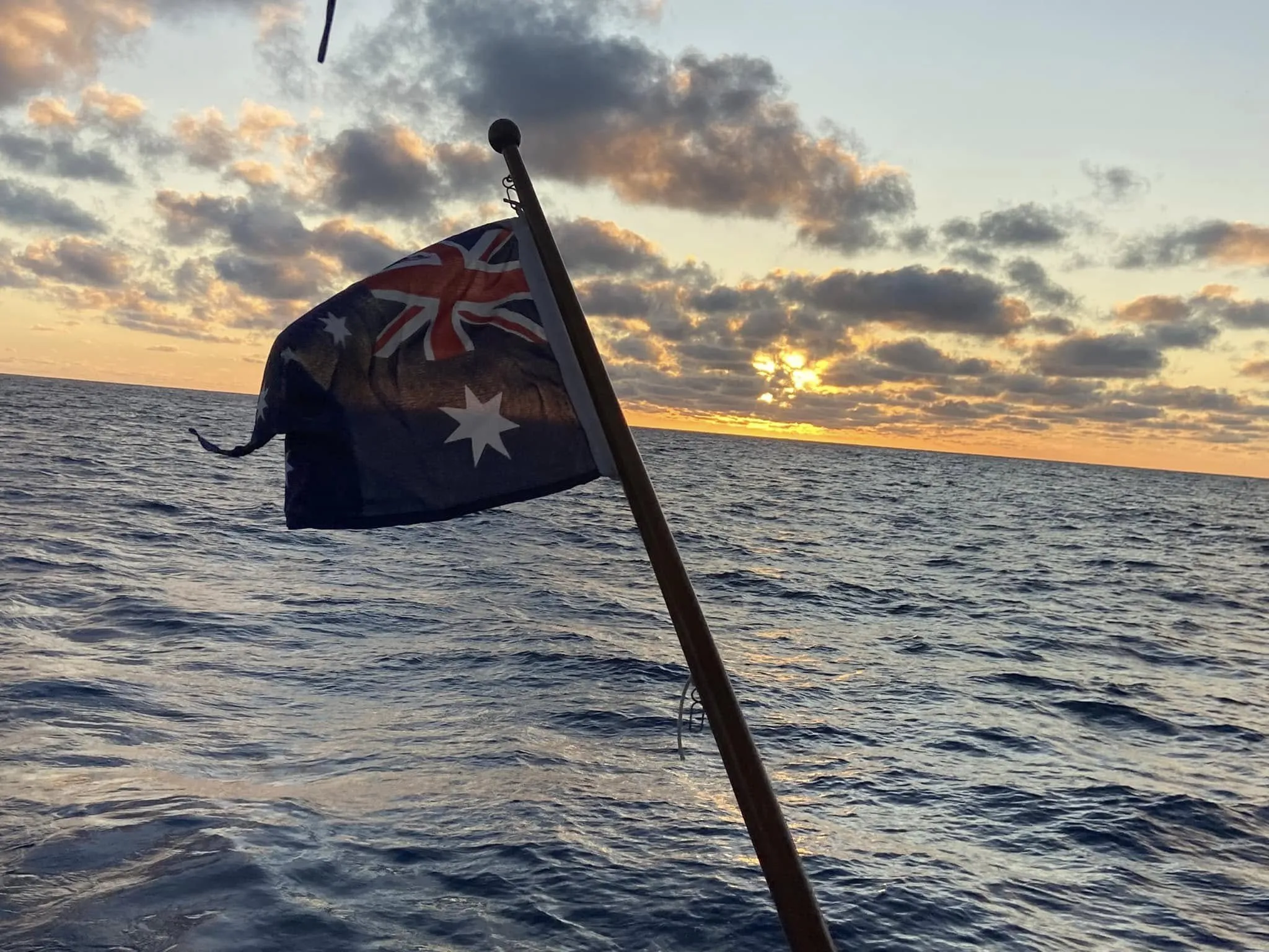 Sea Dragon's Australian flag flying against a sunset over the ocean