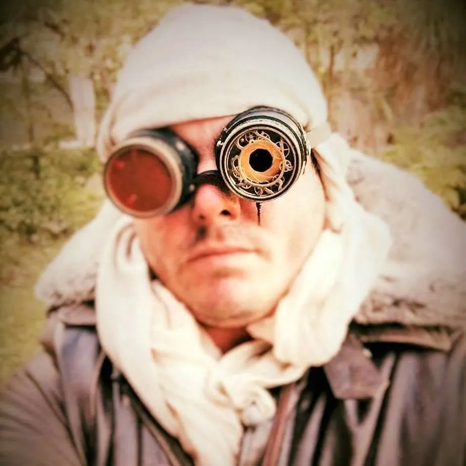 Tim in a head scarf and steampunk goggles