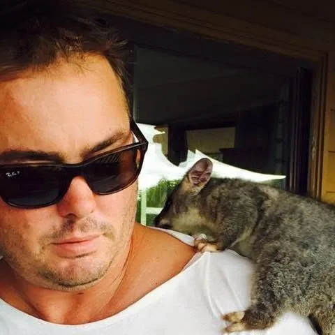 A possum sitting on Tim's shoulder